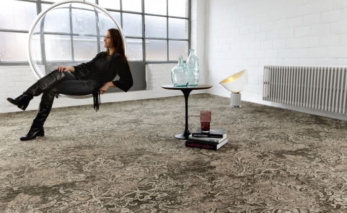 Kobieta siedzi w pomieszczeniu z dużą wykładziną dywanową