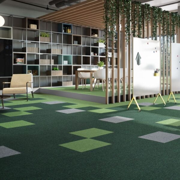Open space biurowca, na podłodze charakterystyczne płytki dywanowe w zielonych barwach